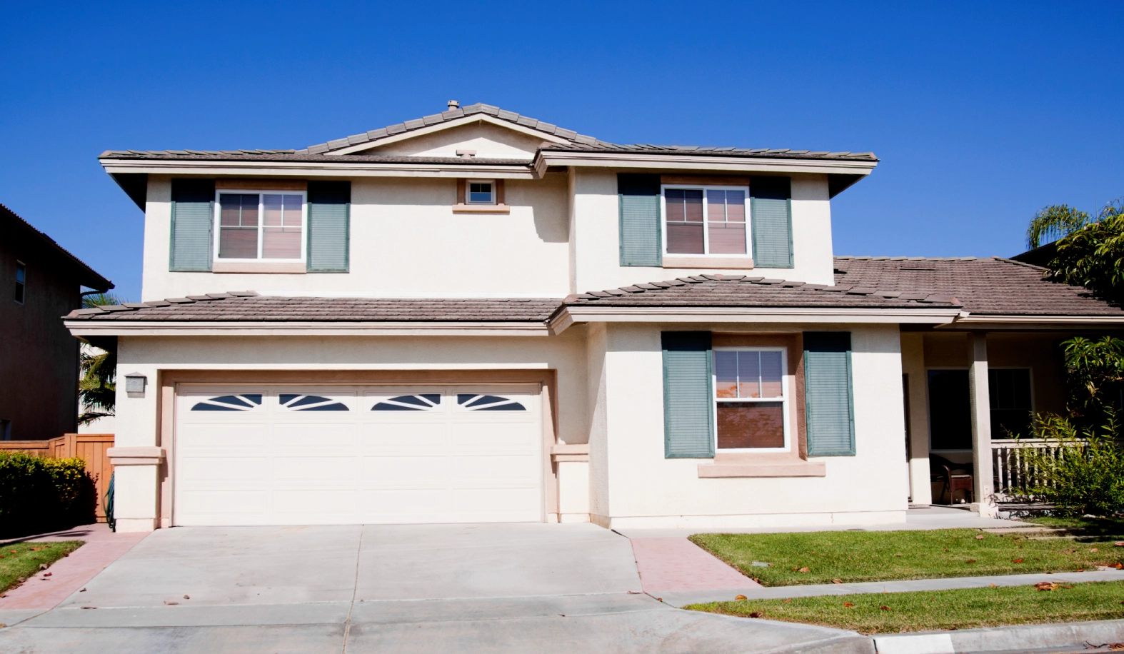 GettyImages-181088401 Stucco home exterior against a clear blue sky near sunset. Typical Southern California architectural style.